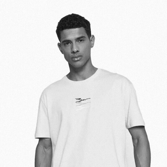 Young man wearing a plain white t-shirt with a subtle logo.