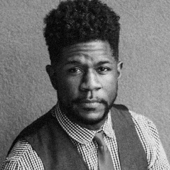Black and white portrait of a man with a vest and tie.