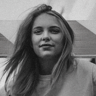 Black and white portrait of a young woman with flowing hair and a gentle smile.