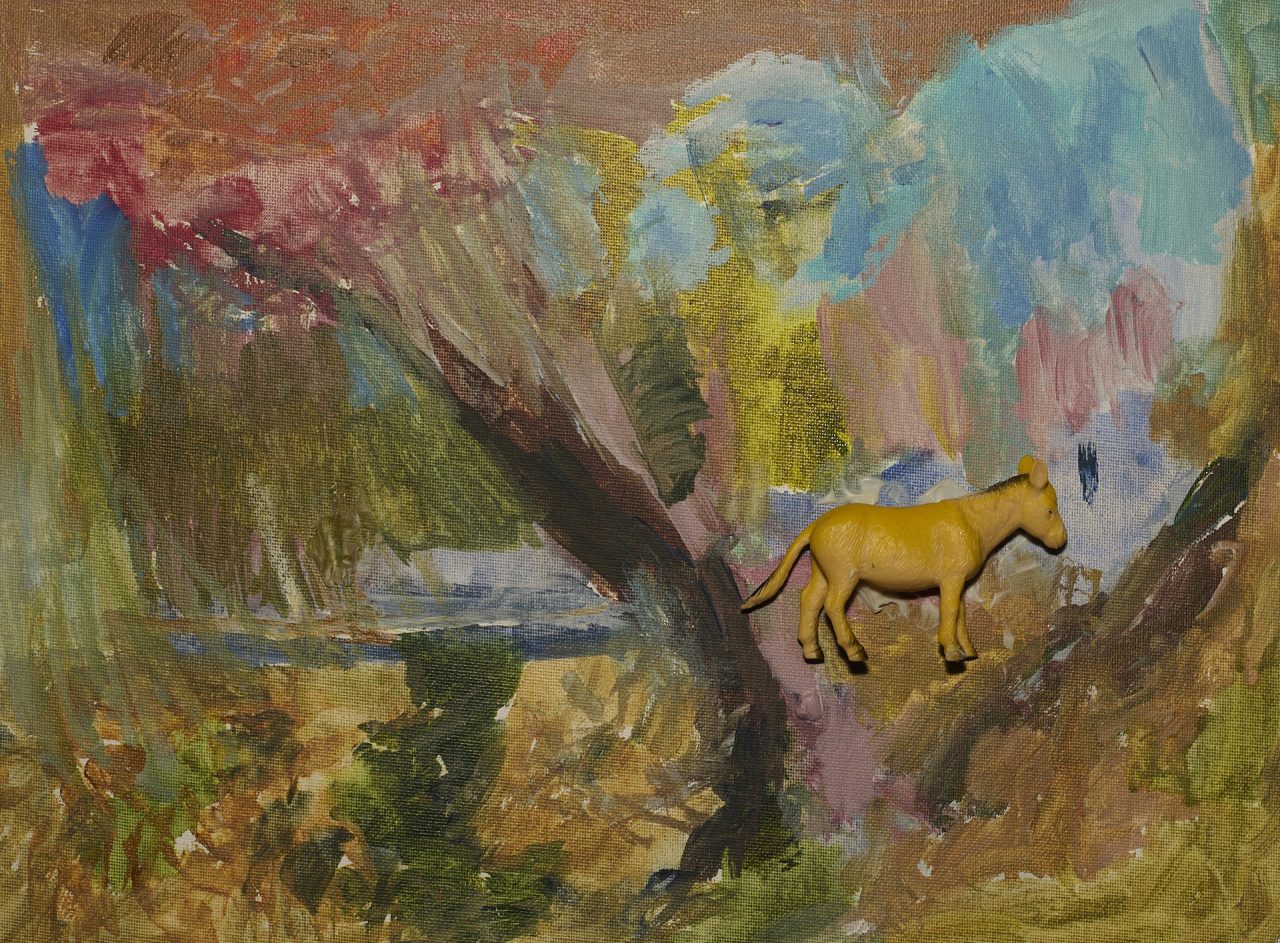 An abstract painting of a yellow horse near a tree with colorful background.