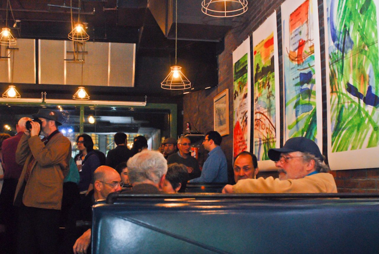 People enjoying conversations in a cozy restaurant with colorful artwork.
