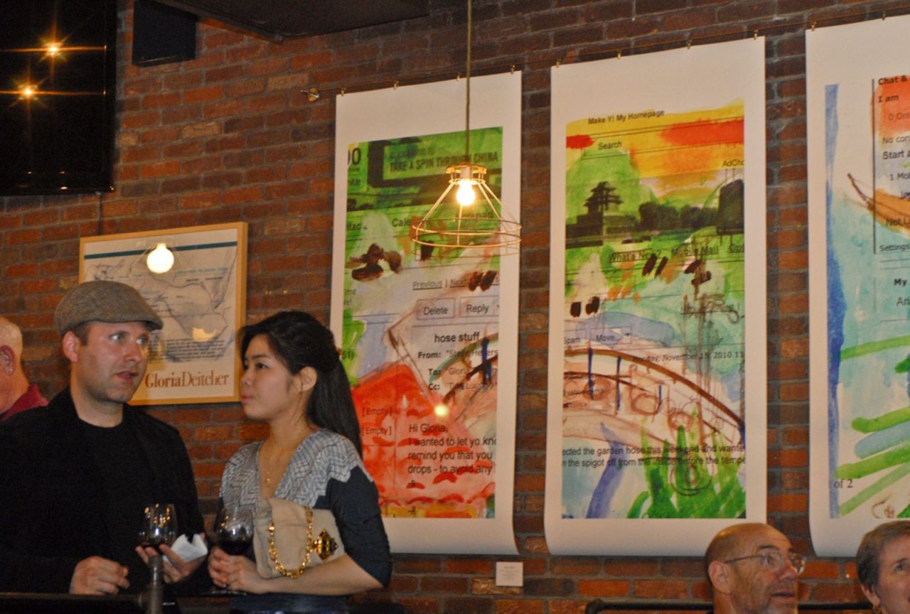 Two women sitting and talking in a cozy café with colorful wall art.