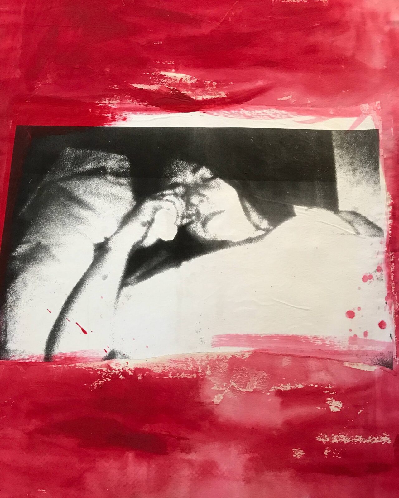 Black and white photo of a person resting with hand near face, framed by a red border.