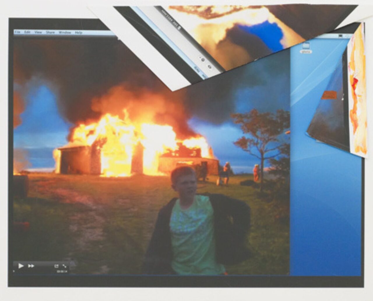 A person stands near a burning building at night.